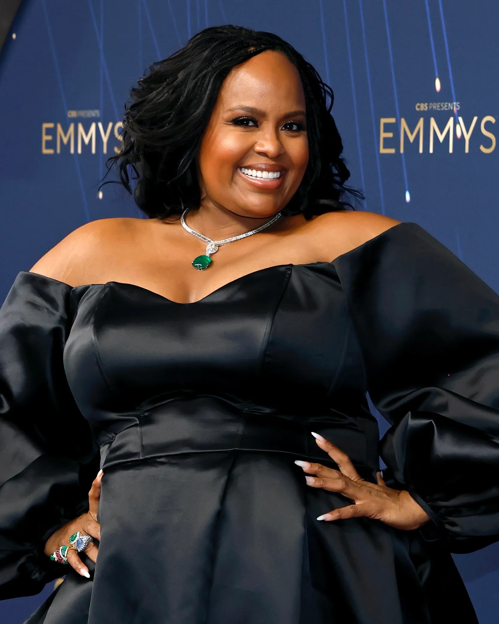 Rothwell deslumbró con un vestido negro off-the-shoulder, elegante y minimalista, que enmarcó a la perfección la pieza protagonista de su look: un collar de diamantes de David Webb, adornado con un enorme colgante de esmeralda que acaparó todas las miradas. Para completar su estilismo, la actriz lució además un conjunto de anillos brillantes, sumando destellos de lujo a cada detalle.Con esta elección, Natasha Rothwell confirmó que la joyería de gran impacto sigue siendo el recurso definitivo para transformar un look clásico en un momento inolvidable en la alfombra roja.